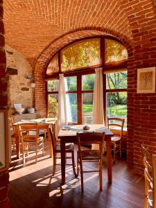 Valdengo的住宿－Il Talucco B&B，一间带两张桌子和大窗户的用餐室