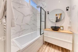 a bathroom with a sink and a mirror at Le Garden City - Bel appartement avec jardin privé in Villeurbanne