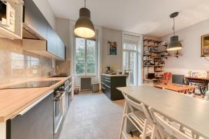 a kitchen with a large counter and a dining room at Le Garden City - Bel appartement avec jardin privé in Villeurbanne