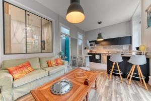 a living room with a couch and a table at Le Garden City - Bel appartement avec jardin privé in Villeurbanne