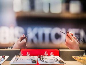 two people sitting at a table with their hands on their chopsticks at ibis Issy les Moulineaux "Val de Seine" in Issy-les-Moulineaux