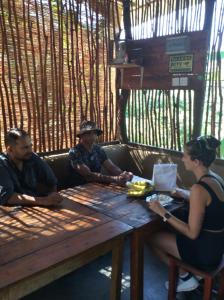 un gruppo di persone seduti intorno a un tavolo di legno di Galaha Eco Camping 1 a Kandy