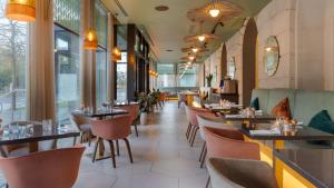 un restaurante con mesas, sillas y ventanas en Hilton Cardiff, en Cardiff