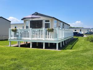 a small house with an umbrella on a deck at Country View C50 in Blue Anchor