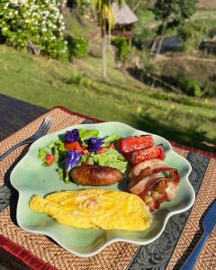 a plate of breakfast food with eggs sausage and vegetables at Kanlaya's Eyrie, Luxury Homestay in Pang Mapha
