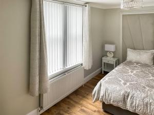 ein Schlafzimmer mit einem Bett und einem großen Fenster in der Unterkunft Lilydale Retreat in Lanchester
