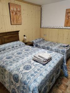 Habitación con 2 camas y toallas. en Casa rural con vistas al parque natural Castril, en Castril