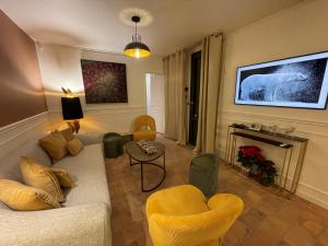sala de estar con sofá y chimenea en La Petite Maison de Giverny Chambres de charme Gîte 5 étoiles au Cœur du village en Giverny