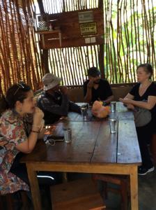 un grupo de personas sentadas alrededor de una mesa de madera en Galaha Eco Camping 1 en Kandy