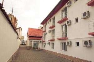 an alley between two white buildings with windows at Pensiunea Johanna in Arad