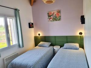 twee bedden in een kamer met een raam bij Les Hauts de Sarlat G4 - Clim Piscine Parking WiFi in Sarlat-la-Canéda