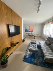 uma sala de estar com 2 sofás e uma televisão de ecrã plano em Sua Casa na melhor localização de Teresópolis em Teresópolis