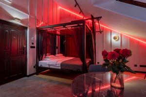 a bedroom with a canopy bed with red lights at Exclusive BDSM Apartment Kraków - ADULTS ONLY in Krakow