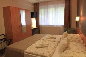 A bed or beds in a room at Zenit Panzió