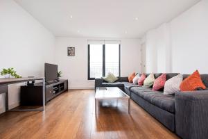 a living room with a couch and a tv at Central 2 Bed Maissonette in London