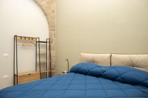 un letto con piumone blu in una camera da letto di Pignuol Rooms - nel cuore di Marigliano a Marigliano