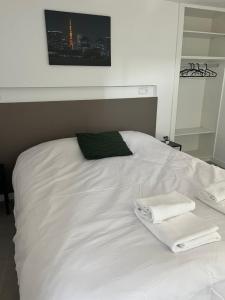 Una cama blanca con toallas encima. en Hostal La Masia, en Manresa