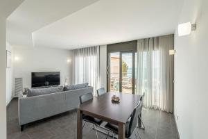 a living room with a couch and a table at Apartamento ático primera línea Playa Canyelles in Roses