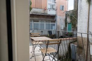 una mesa y sillas en el balcón de un edificio en Pignuol Rooms - nel cuore di Marigliano, en Marigliano