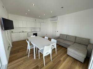 salon z białym stołem i kanapą w obiekcie Marina Dream Beach Apartments with Sea View Terrace - Agenzia Cocal w Caorle
