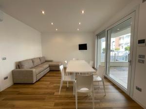 salon ze stołem i kanapą w obiekcie Marina Dream Beach Apartments with Sea View Terrace - Agenzia Cocal w Caorle