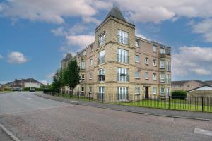 a large brick building on the side of a street at Pure Apartments 2 Bed Duloch - Dunfermline in Fife