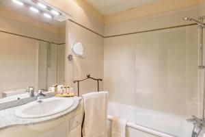 ein Badezimmer mit einem Waschbecken, einer Badewanne und einer Dusche in der Unterkunft Hôtel Le Maxime - Best Western Signature Collection in Auxerre