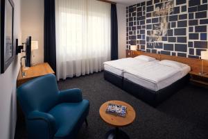 a hotel room with a bed and a chair at Hotel Hamburg-Wittenburg van der Valk in Wittenburg +50 photos