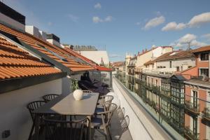 a table and chairs on a balcony with a view at Líbere Bilbao Ledesma in Bilbao