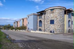 un edificio de piedra al lado de una calle en SHR Residence Valledoria Int 25, en Codaruina