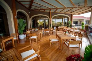 Hilton Alexandria King's Ranch Hotel في الإسكندرية: مطعم فارغ بطاولات وكراسي خشبية