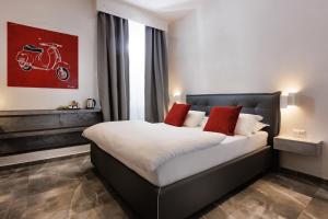 a bedroom with a large bed with a motorcycle painting on the wall at DolceVitaSuite in Rome