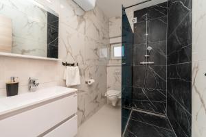 een badkamer met douche, toilet en wastafel bij La Vie luxury apartments with a pool in Stara Novalja +195 foto's