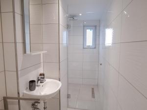 a white bathroom with a sink and a shower at Haus Boutique in Bad Salzuflen