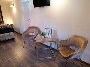 巴特薩爾茨烏夫倫的住宿－Haus Boutique，客厅配有两把椅子和一张桌子