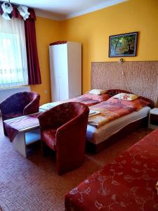 - une chambre avec un grand lit et une chaise dans l'établissement Apart Júlia Villa, à Hévíz