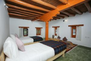 une chambre avec deux lits dans une pièce dans l'établissement Shel Heritage Home, à Leh