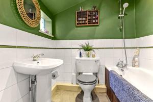a bathroom with a sink and a toilet and a tub at Victorian cottage in Brixton! in London