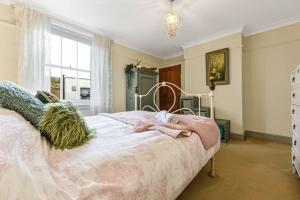 a bedroom with a bed and a window at Victorian cottage in Brixton! in London