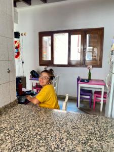 a woman sitting at a counter in a kitchen at Esperanto hostel in Salta