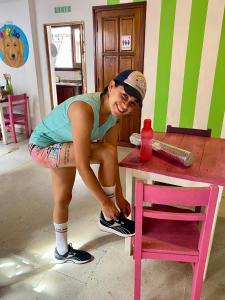 a woman is standing next to a pink chair at Esperanto hostel in Salta