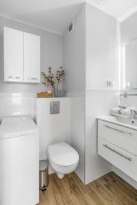 a white bathroom with a toilet and a sink at Downtown Oasis on foot to Central station parking metro smartTv WiFi in Warsaw