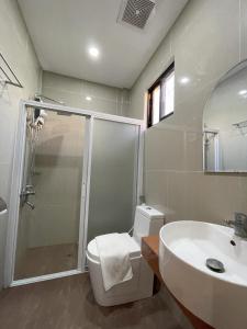 a bathroom with a shower and a toilet and a sink at Noah's Ark Hotel powered by Cocotel in Dauis