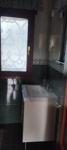 a bathroom with a white sink and a window at Mar del Norte in Salamir