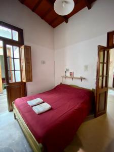 サルタにあるEsperanto hostelのベッドルーム1室(赤いベッド1台、タオル2枚付)