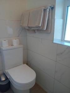 a bathroom with a white toilet and towels at Fairwinds Guest Accommodation in Doolin