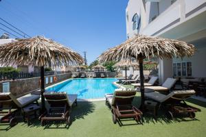 a resort with a swimming pool with chairs and umbrellas at Hotel Venetia in Perdika