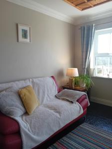 a living room with a couch and a window at Fairwinds Guest Accommodation in Doolin
