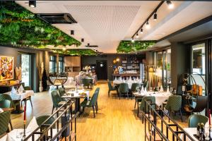 a restaurant with tables and chairs and plants at Hotel Adriale in Kreševo