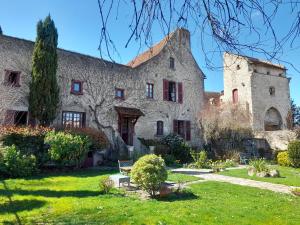 an old stone house with a yard at La Maison du Prince de Condé in Charroux-dʼAllier